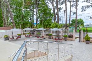 a patio with tables and chairs in a park at Samni Hotel in Ureki