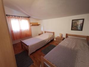 a bedroom with two beds and a window at Apartments Luca in Zaboric