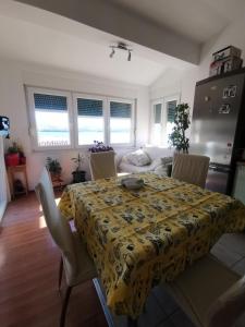 einen Esstisch mit einem gelben Tischtuch darauf in der Unterkunft Apartments Luca in Zaboric