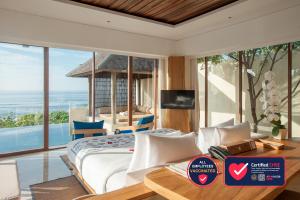 a bedroom with a bed and a view of the ocean at Komaneka at Keramas Beach in Keramas