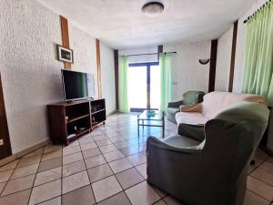 a living room with a couch and a tv at Villa Ela in Postira