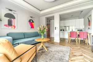 salon z niebieską kanapą i różowymi krzesłami w obiekcie City Apartments - Apartamenty Butikowe w Koszalinie
