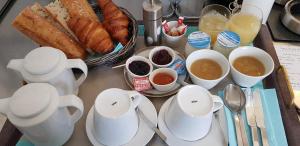 a table with croissants and cups of coffee and bread at Hotel et Spa Les Cleunes Oléron in Saint-Trojan-les-Bains