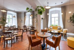 a restaurant with tables and chairs and a waiting room at JUFA Hotel Judenburg in Judenburg