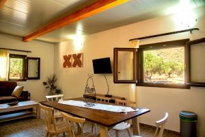 a living room with a wooden table and chairs at flamingo colour valey house in Palekastron