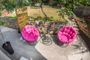 3 chaises roses assises sur un patio dans l'établissement Sweet, à Rovinj