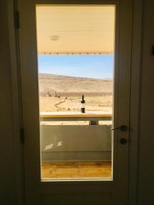 a window in a door looking out at the desert at פטריוט -יקב ננה in Mitzpe Ramon