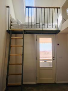 a bunk bed in a room with a door and a window at פטריוט -יקב ננה in Mitzpe Ramon
