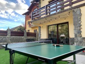 Holiday Home in Sinaia في سينيا: طاولة بينج بونغ أمام المنزل