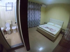 a small bedroom with a bed and a toilet at Central Hostel in Shkodër