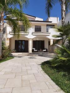 a large white house with palm trees in front of it at Villa Silvana in Lecce