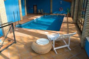 a swimming pool with a table and a bench next to it at Complejo Molí de L'Hereu in Ráfales