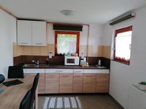 a kitchen with a table and a microwave at Csónakos Vendégház in Tiszafüred