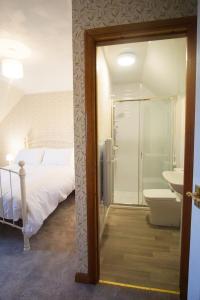 a bedroom with a bed and a bathroom with a sink at Remuera, North Tolsta in North Tolsta
