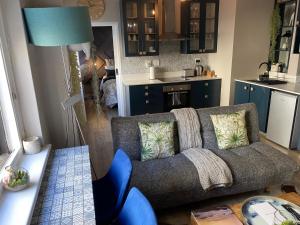 a living room with a couch and a kitchen at Just Off Long - Inner City Gem in Cape Town