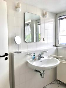 Baño blanco con lavabo y espejo en Ferienwohnung Villy Seepark 711, en Heringsdorf