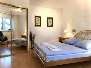1 dormitorio con 1 cama grande y espejo en Ferienwohnung Villy Seepark 711, en Heringsdorf