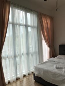a bedroom with a bed and a large window at Play Residence at Golden Hills in Cameron Highlands