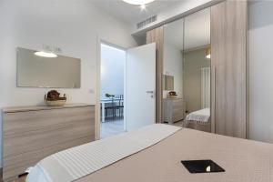 a bedroom with a bed and a mirror at Residence Armony in Misano Adriatico