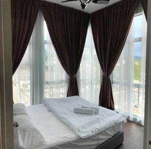 a bedroom with a bed and large windows at Play Residence at Golden Hills in Cameron Highlands