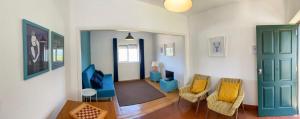 una sala de estar con una puerta azul y sillas en Casas da Loureira - Casa da Piscina e Batatas II en Vila Nova de Cerveira