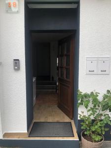 eine Tür, die in einen Flur mit einer Pflanze führt in der Unterkunft Seven‘S Apartments I in Löhnberg