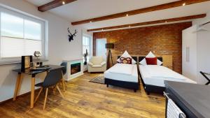 ein Schlafzimmer mit zwei Betten und einer Ziegelwand in der Unterkunft Pension Bottwartal in Abstatt
