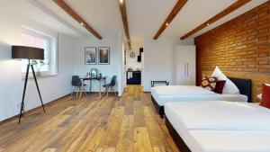 1 dormitorio con 2 camas y pared de ladrillo en Pension Bottwartal en Abstatt