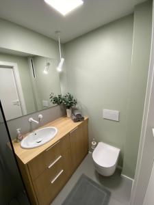 a bathroom with a sink and a toilet and a mirror at Apartament Narcyzowa in Gdynia