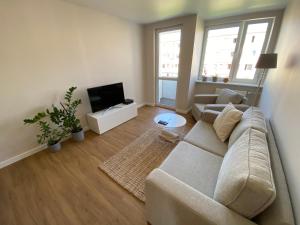 a living room with a couch and a flat screen tv at Apartament Narcyzowa in Gdynia