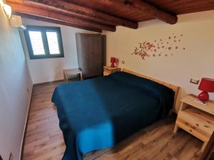 a bedroom with a blue bed and wooden floors at Villa Sole - Finaiti - Appartamento per turisti in Floridia