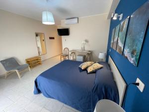 a blue bedroom with a bed and a blue wall at Agriturismo Villa Orchidea in Alì Terme