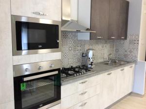 a kitchen with a stove and a microwave at Brevi vacanze a Brolo in Brolo +7 photos