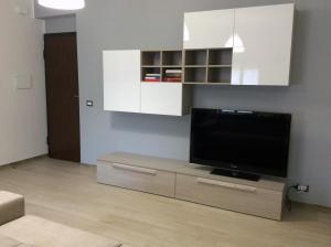 a living room with a flat screen tv on a cabinet at Brevi vacanze a Brolo in Brolo