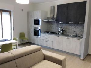 a living room with a couch and a kitchen at Brevi vacanze a Brolo in Brolo