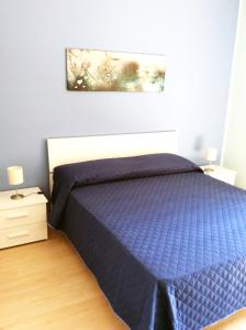 - une chambre avec un lit et une couette bleue dans l'établissement Brevi vacanze a Brolo, à Brolo