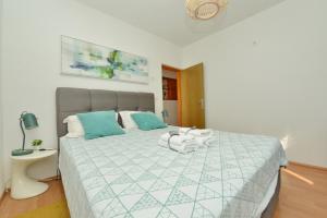 ein Schlafzimmer mit einem großen Bett mit blauen Kissen in der Unterkunft Beautiful 1-Bed Apartment Kristijan Zadar in Zadar