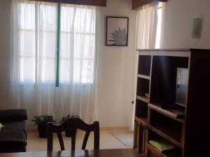 a living room with a tv and a table and a chair at CASA SARA in Parque Holandes