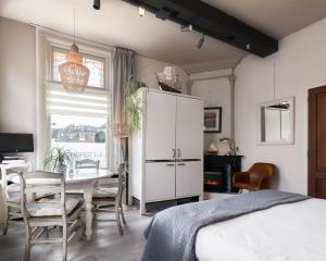 a bedroom with a table and a white cabinet at De Juttershoek Centrum in Kampen