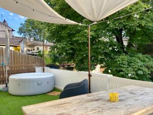 a wooden table with an umbrella on a backyard at Bel appart pour 6 p, clim, parking et terrasse in Aix-en-Provence +7 photos
