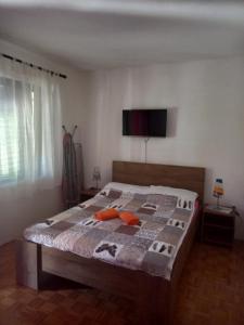1 dormitorio con 1 cama y TV en la pared en Dubravka 1, en Funtana