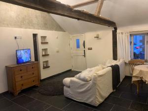 a living room with a white couch and a tv at Beautiful 1-Bed House in Gloucestershire in Westbury on Severn