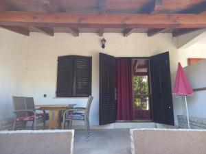 a patio with a table and chairs and a window at Dubravka 1 in Funtana