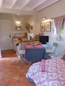 a living room with a table and a kitchen at Les Petits Matins Bleus - Chambres d'hôtes "Les Pommiers" in Sainte-Marguerite-de-Viette