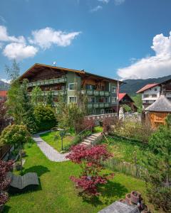 an apartment building with a garden in front of it at Hotel "Zum Ritter" in Tannheim