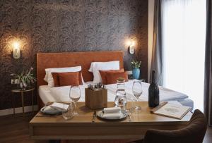 Schlafzimmer mit einem Bett und einem Tisch mit Weingläsern in der Unterkunft Stadthotel in Kaiserslautern