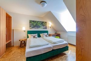 a bedroom with a large bed with a green headboard at Stadthotel in Kaiserslautern