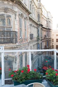 a balcony with red flowers on a building at Galata Life Istanbul in Istanbul