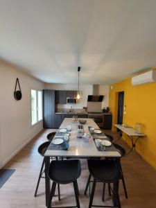 a room with a table and chairs and a kitchen at Gite des vendangeurs 4 étoiles - 10 personnes in Bourg-sur-Gironde