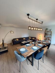 una sala de estar con una gran mesa de madera y sillas en Gite des vendangeurs 4 étoiles - 10 personnes, en Bourg-sur-Gironde